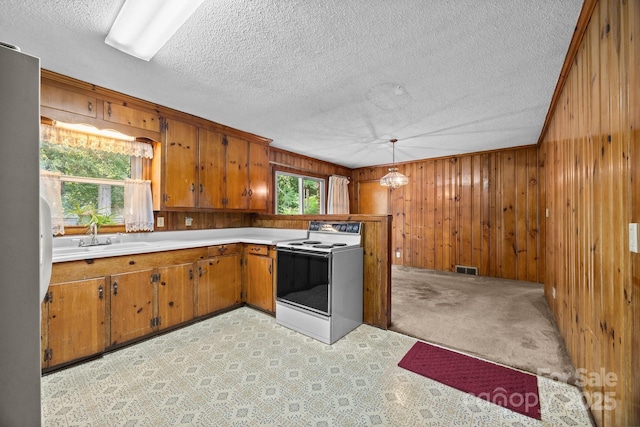 331 Elwood St, Kannapolis, NC 28081 - kitchen featuring white electric stove, brown cabinets, light countertops, wooden walls, and a textured ceiling