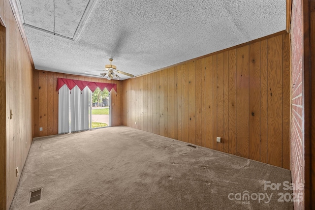 331 Elwood St, Kannapolis, NC 28081 - unfurnished room with carpet floors, attic access, wood walls, a textured ceiling, and ceiling fan