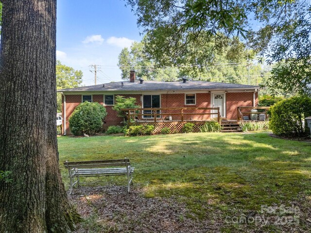 331 Elwood St, Kannapolis, NC 28081 - back of house with brick siding, a yard, a wooden deck, and a chimney