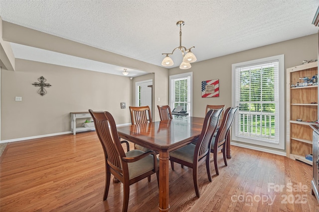 1921 Williford Woods Ln, Rock Hill, SC 29730 - dining room with light wood-type flooring, a chandelier, and a textured ceiling