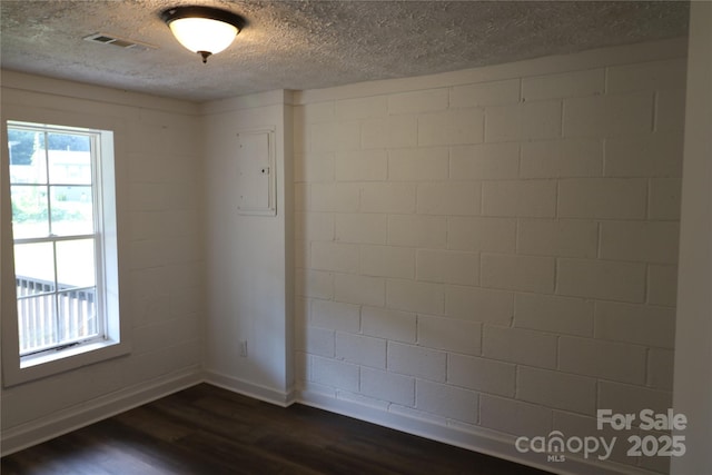 127 Setzer St, Spindale, NC 28160 - spare room with dark wood-type flooring, electric panel, a textured ceiling, and concrete block wall
