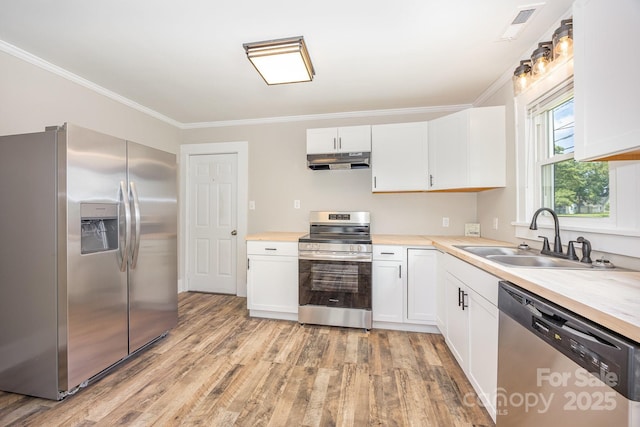 900 N Salisbury Ave, Spencer, NC 28159 - kitchen featuring appliances with stainless steel finishes, under cabinet range hood, light wood finished floors, crown molding, and white cabinetry