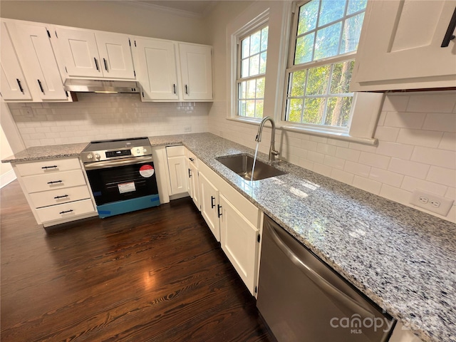 179 Duval St NW, Concord, NC 28025 - kitchen with appliances with stainless steel finishes, under cabinet range hood, ornamental molding, dark wood finished floors, and light stone counters