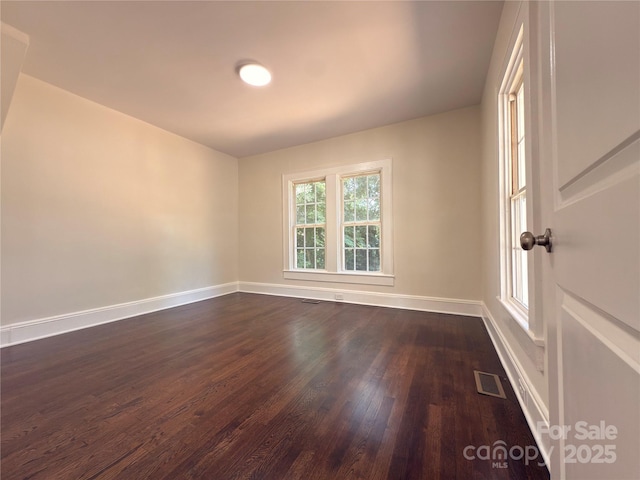 179 Duval St NW, Concord, NC 28025 - spare room featuring baseboards and dark wood-type flooring