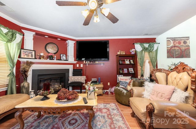 5448 Wyalong Dr, Charlotte, NC 28227 - living area with a ceiling fan, wood finished floors, ornamental molding, a glass covered fireplace, and decorative columns