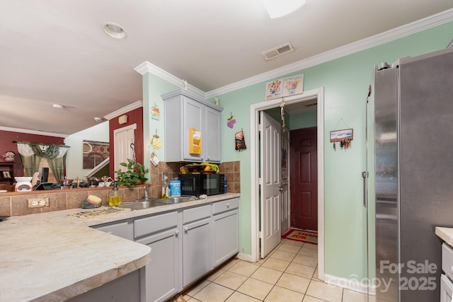 5448 Wyalong Dr, Charlotte, NC 28227 - kitchen with freestanding refrigerator, ornamental molding, black microwave, light countertops, and light tile patterned floors