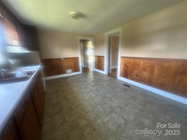 162 Bartley St, Spindale, NC 28160 - unfurnished dining area with a wainscoted wall, wood walls, tile patterned floors, and a desk