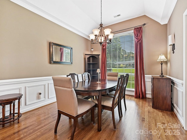 1842 Caroline Way, Fort Mill, SC 29715 - dining space featuring a chandelier, a decorative wall, light wood-style flooring, lofted ceiling, and a wainscoted wall