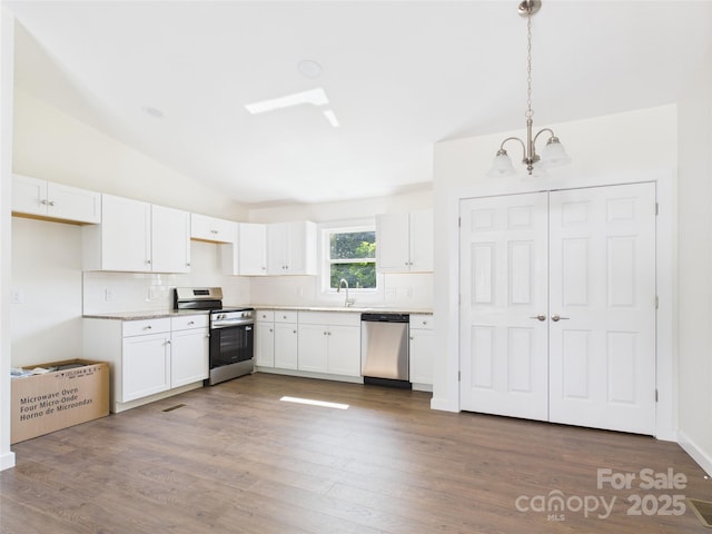 39 Pearl St, Granite Falls, NC 28630 - kitchen with appliances with stainless steel finishes, a chandelier, lofted ceiling, backsplash, and white cabinetry