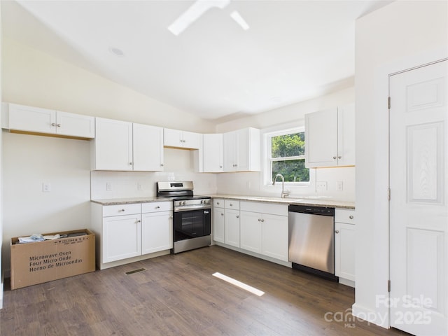 39 Pearl St, Granite Falls, NC 28630 - kitchen featuring appliances with stainless steel finishes, tasteful backsplash, vaulted ceiling, white cabinetry, and dark wood-type flooring