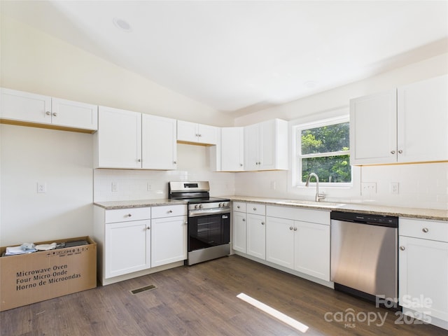 39 Pearl St, Granite Falls, NC 28630 - kitchen featuring stainless steel appliances, decorative backsplash, lofted ceiling, white cabinetry, and dark wood-style floors