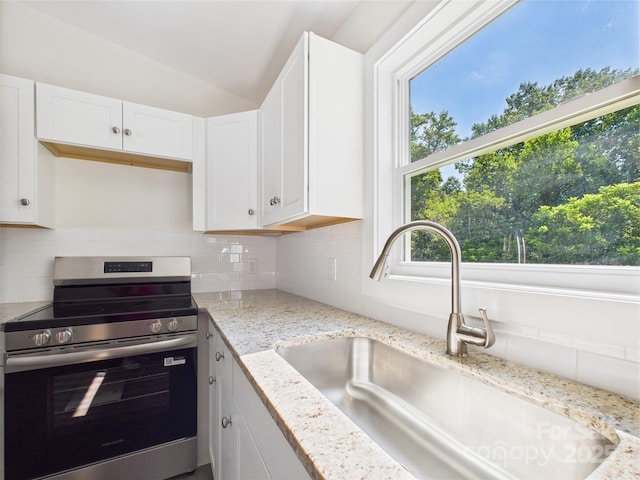 39 Pearl St, Granite Falls, NC 28630 - kitchen with stainless steel electric stove, decorative backsplash, white cabinetry, light stone countertops, and lofted ceiling