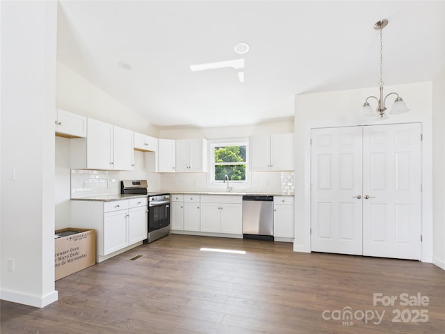 39 Pearl St, Granite Falls, NC 28630 - kitchen featuring appliances with stainless steel finishes, lofted ceiling, backsplash, a chandelier, and white cabinetry