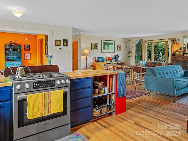 32 Sugar Cove Rd, Weaverville, NC 28787 - kitchen featuring stainless steel gas range, light wood finished floors, blue cabinets, open floor plan, and butcher block counters