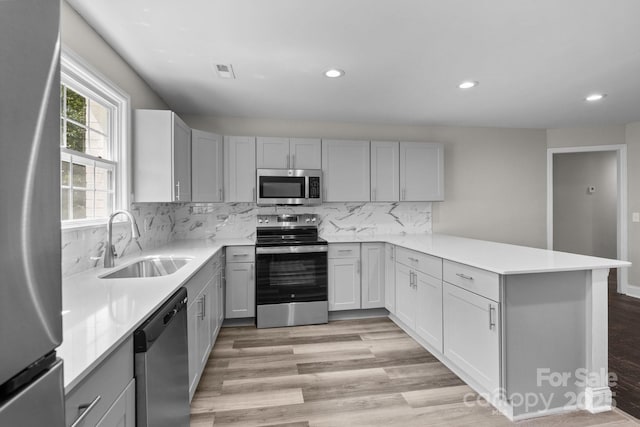 509 8th Avenue Ext, Cramerton, NC 28032 - kitchen featuring stainless steel appliances, gray cabinetry, recessed lighting, a peninsula, and light wood finished floors