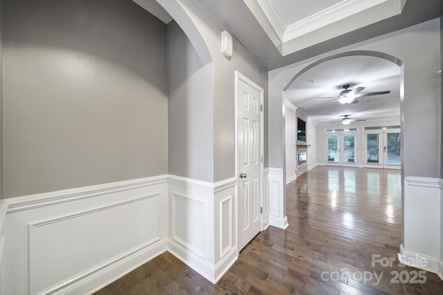 329 Wave Crest Dr, Tega Cay, SC 29708 - corridor featuring dark wood-style floors, arched walkways, crown molding, a tray ceiling, and wainscoting