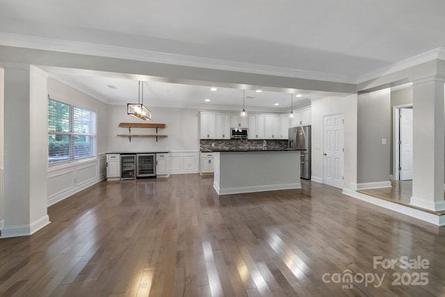 329 Wave Crest Dr, Tega Cay, SC 29708 - unfurnished living room featuring wine cooler, dark wood-style floors, decorative columns, and ornamental molding
