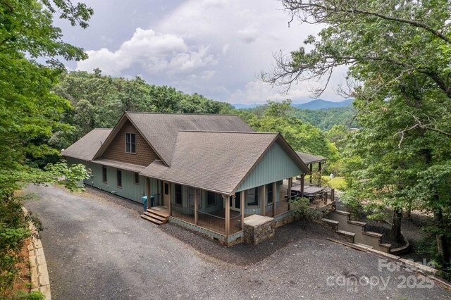 486 Center Dr Unit 7B, Bryson City, NC 28713 - view of front of property with a porch, a shingled roof, driveway, and a forest view