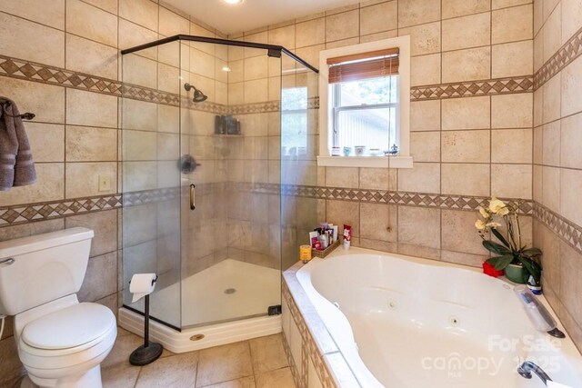 486 Center Dr Unit 7B, Bryson City, NC 28713 - bathroom with tile walls, a tub with jets, a stall shower, and tile patterned floors