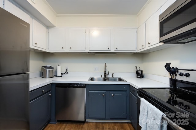 2620 Park Rd Unit F, Charlotte, NC 28209 - kitchen featuring appliances with stainless steel finishes, blue cabinets, crown molding, white cabinetry, and dark wood finished floors