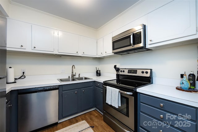 2620 Park Rd Unit F, Charlotte, NC 28209 - kitchen featuring appliances with stainless steel finishes, ornamental molding, dark wood-style floors, white cabinetry, and light countertops