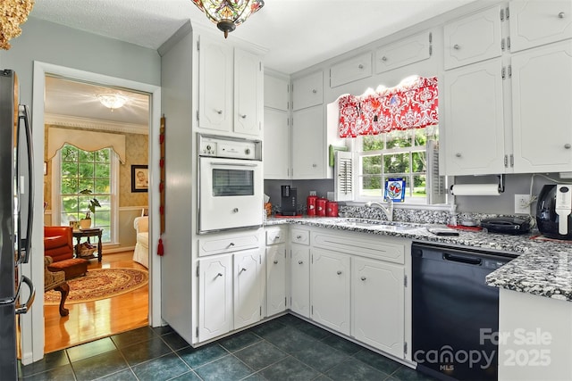 701 4th Ave NE, Conover, NC 28613 - kitchen with black appliances, dark tile patterned flooring, white cabinets, crown molding, and light stone countertops