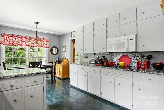 701 4th Ave NE, Conover, NC 28613 - kitchen with white microwave, white cabinetry, pendant lighting, stone countertops, and a textured ceiling