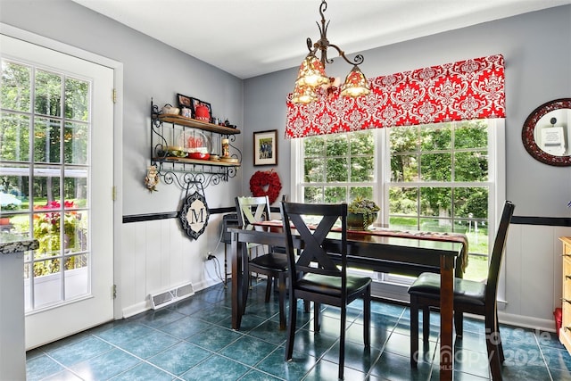 701 4th Ave NE, Conover, NC 28613 - dining space featuring healthy amount of natural light, wainscoting, dark tile patterned flooring, and a chandelier