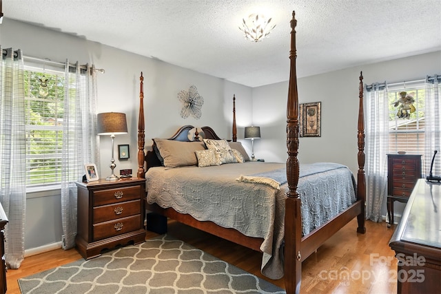 701 4th Ave NE, Conover, NC 28613 - bedroom with wood finished floors, multiple windows, and a textured ceiling