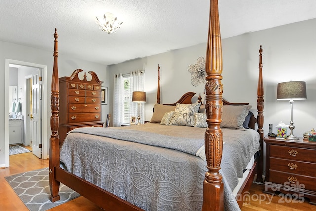 701 4th Ave NE, Conover, NC 28613 - bedroom with wood finished floors, a textured ceiling, and ensuite bath