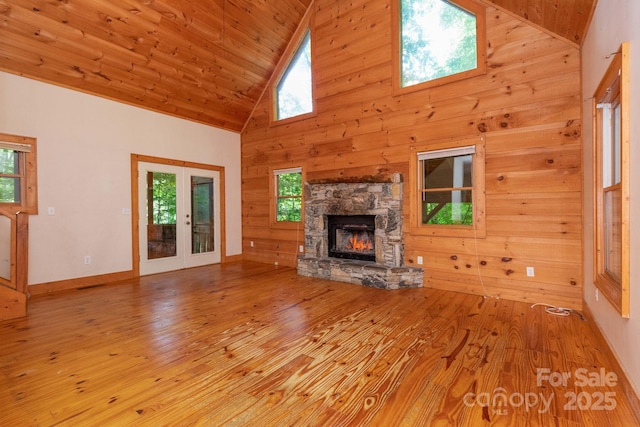 25 Trillium Trce, Maggie Valley, NC 28751 - unfurnished living room with high vaulted ceiling, wood finished floors, a stone fireplace, wood walls, and wooden ceiling