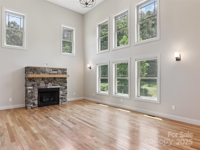 278 Ollie Weaver Rd, Weaverville, NC 28787 - unfurnished living room with wood finished floors, healthy amount of natural light, a fireplace, and a towering ceiling