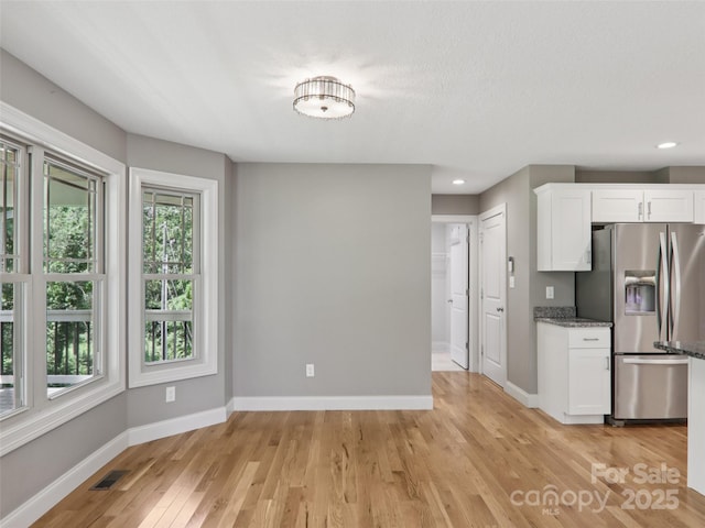 278 Ollie Weaver Rd, Weaverville, NC 28787 - kitchen with stainless steel fridge with ice dispenser, white cabinets, light wood-style floors, stone countertops, and recessed lighting