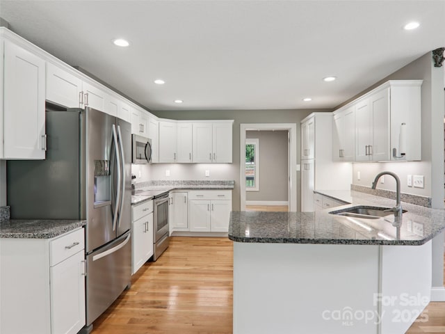 278 Ollie Weaver Rd, Weaverville, NC 28787 - kitchen with stainless steel appliances, a peninsula, light wood finished floors, white cabinetry, and recessed lighting