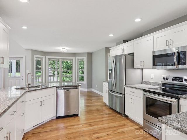 278 Ollie Weaver Rd, Weaverville, NC 28787 - kitchen with stainless steel appliances, recessed lighting, light wood-type flooring, white cabinets, and light stone countertops