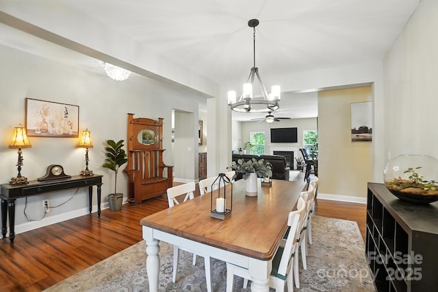 1006 Spring Rose Ln, Matthews, NC 28104 - dining area with a chandelier, wood finished floors, a fireplace, and ceiling fan