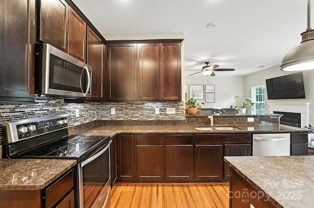 1006 Spring Rose Ln, Matthews, NC 28104 - kitchen with stainless steel appliances, open floor plan, a ceiling fan, light wood-type flooring, and decorative backsplash
