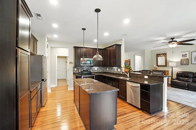 1006 Spring Rose Ln, Matthews, NC 28104 - kitchen with stainless steel appliances, open floor plan, light wood-type flooring, a center island, and recessed lighting
