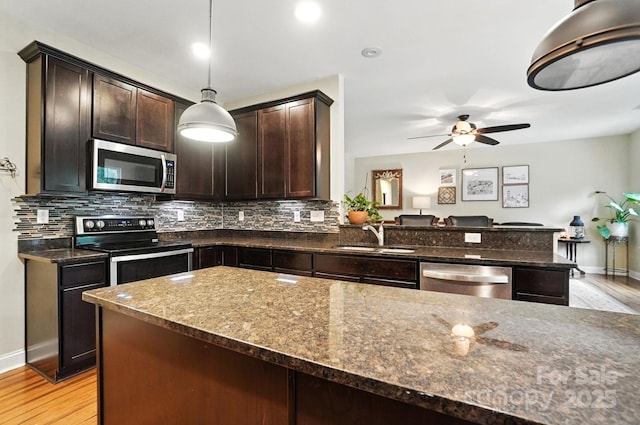 1006 Spring Rose Ln, Matthews, NC 28104 - kitchen with stainless steel appliances, dark brown cabinets, dark stone countertops, and tasteful backsplash
