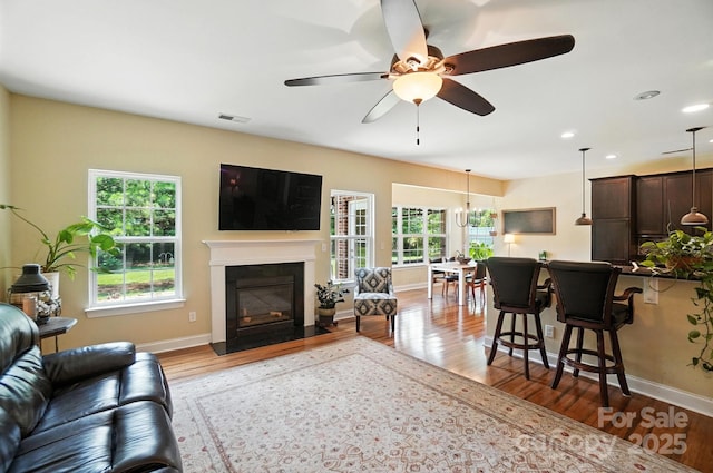 1006 Spring Rose Ln, Matthews, NC 28104 - living area with wood finished floors, a fireplace with flush hearth, a ceiling fan, and recessed lighting