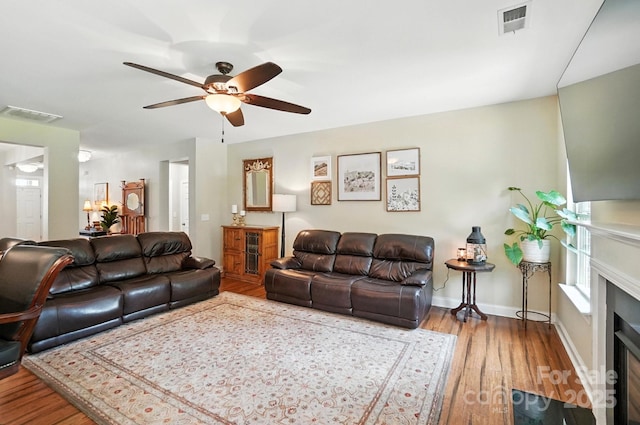 1006 Spring Rose Ln, Matthews, NC 28104 - living room with wood finished floors, a ceiling fan, and a fireplace with flush hearth