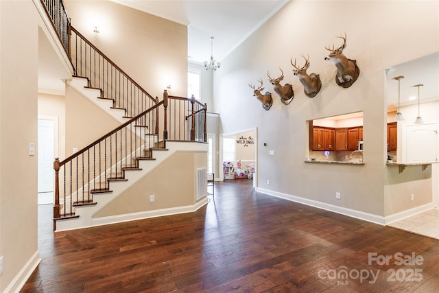 4203 Flint Dr, Lancaster, SC 29720 - unfurnished living room with hardwood / wood-style flooring, stairway, crown molding, a chandelier, and a high ceiling