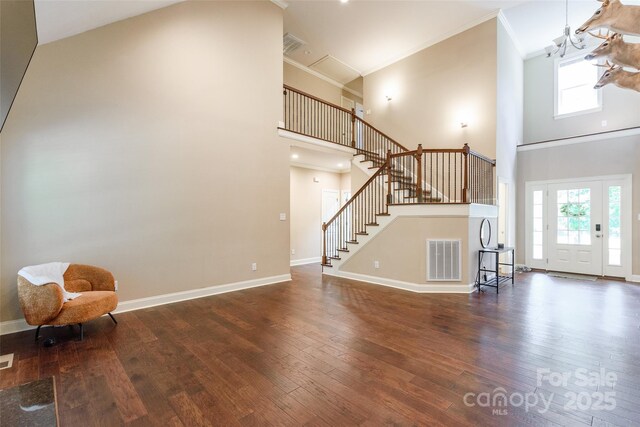 4203 Flint Dr, Lancaster, SC 29720 - unfurnished living room featuring stairway, hardwood / wood-style floors, a towering ceiling, plenty of natural light, and ornamental molding