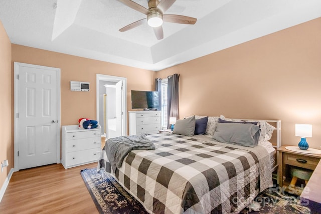 4614 Jacquelyne Dr, Indian Trail, NC 28079 - bedroom featuring a tray ceiling, light wood-style flooring, a ceiling fan, and ensuite bath