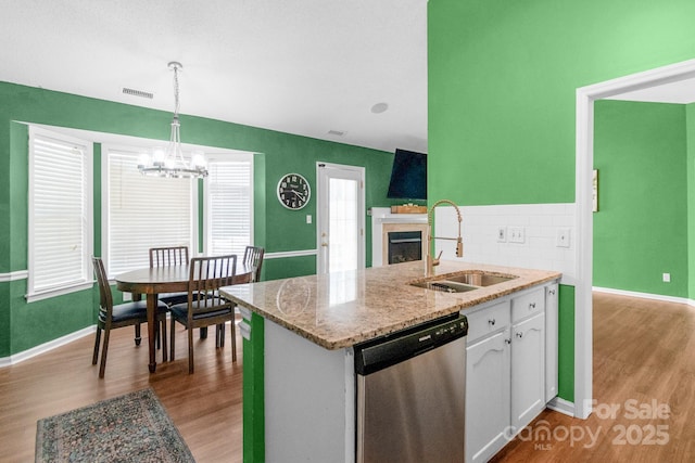4614 Jacquelyne Dr, Indian Trail, NC 28079 - kitchen with stainless steel dishwasher, a chandelier, wood finished floors, a fireplace, and white cabinets