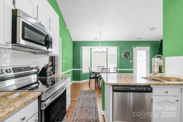 4614 Jacquelyne Dr, Indian Trail, NC 28079 - kitchen with appliances with stainless steel finishes, white cabinets, backsplash, and light wood-style floors