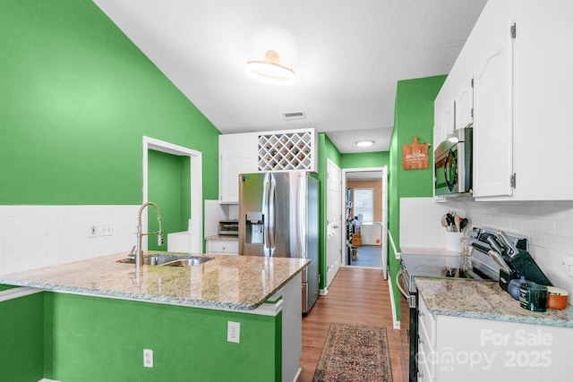 4614 Jacquelyne Dr, Indian Trail, NC 28079 - kitchen featuring stainless steel appliances, tasteful backsplash, white cabinets, light wood-type flooring, and light stone countertops