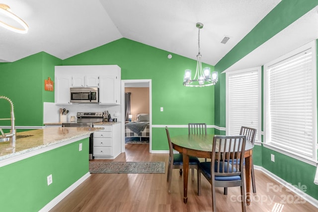 4614 Jacquelyne Dr, Indian Trail, NC 28079 - dining room with wood finished floors, lofted ceiling, and a chandelier