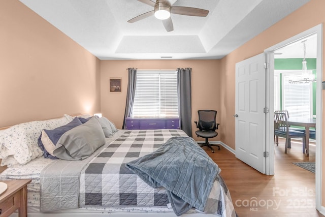 4614 Jacquelyne Dr, Indian Trail, NC 28079 - bedroom featuring a raised ceiling, wood finished floors, multiple windows, and a ceiling fan
