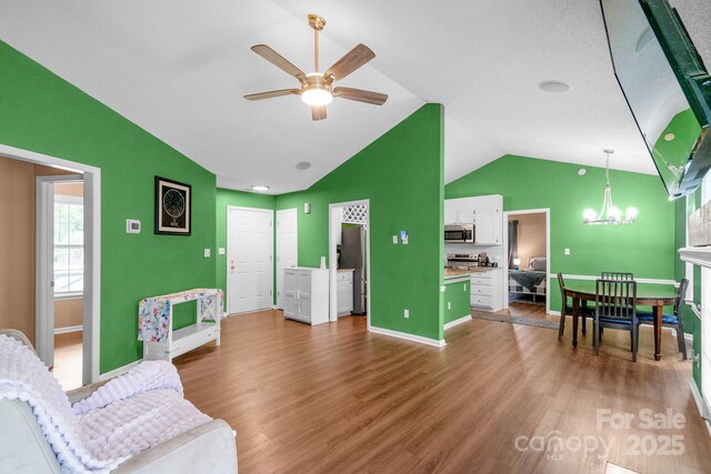 4614 Jacquelyne Dr, Indian Trail, NC 28079 - living room with vaulted ceiling, a ceiling fan, a chandelier, and wood finished floors